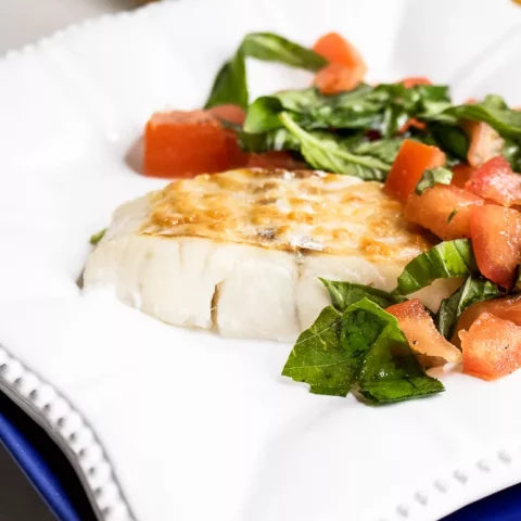 Raise your dinner game with this Parmesan Haddock recipe, topped with fresh tomatoes and fragrant basil. Perfect for a quick and tasty weeknight meal! #QuickRecipes #SeafoodLovers #HealthyEating